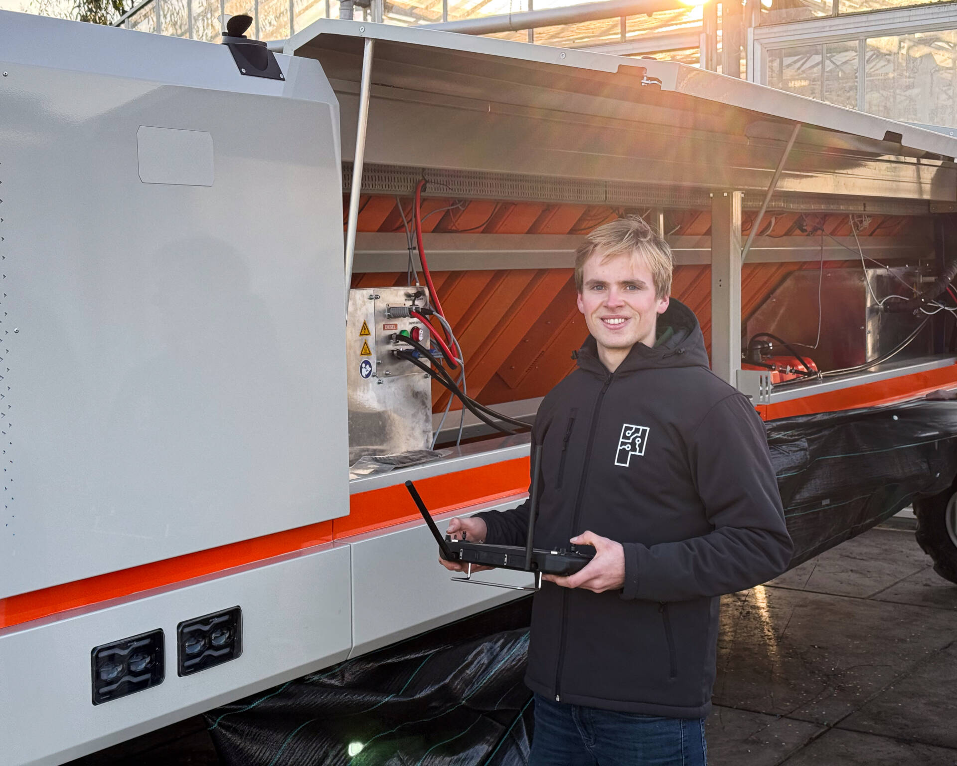 Stagiair Daniel naast Robot One met range extenders geïnstalleerd